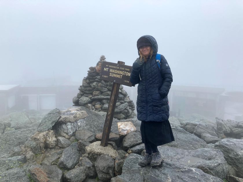 Standing near Mt. Washington Summit sign in foggy weather