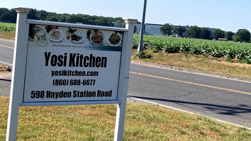 Yosi Kosher Kitchen sign by the road in front of the fields in Windsor, CT